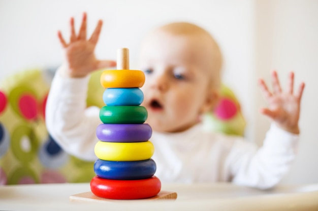 El niño juega a la pirámide. niño jugando con juguetes de madera