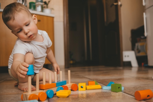 Foto niño juega un tren en casa en el suelo