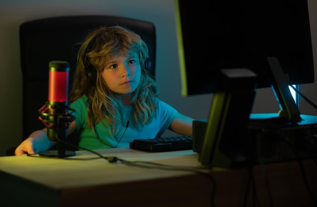 Niño juega un videojuego en la pantalla de la computadora del PC Jugador juega juegos de computadora Iluminación de neón