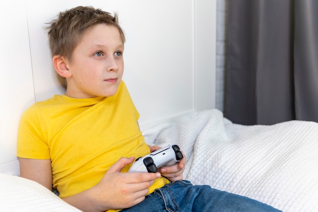 Niño, juego, consola de juegos, acostado, en la cama