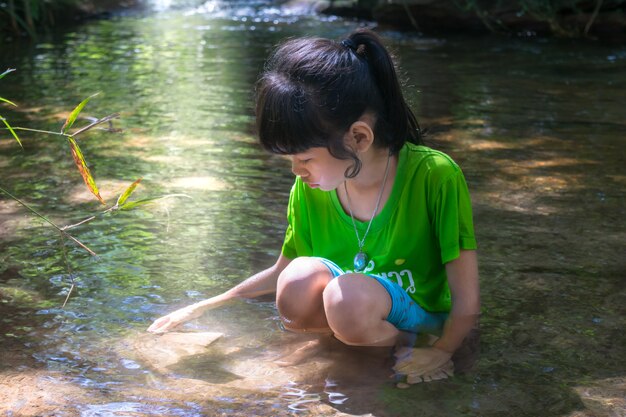 niño jugando agua en el río