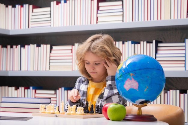 Niño jugando ajedrez inteligente concentrado y pensando niño jugando ajedrez niño desarrollando ajedrez