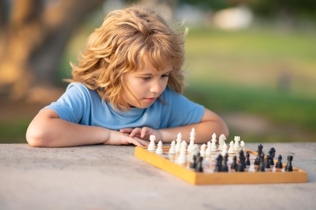 Niño jugando ajedrez en el patio trasero tendido sobre el césped niño concentrado jugando ajedrez niño jugando tablero