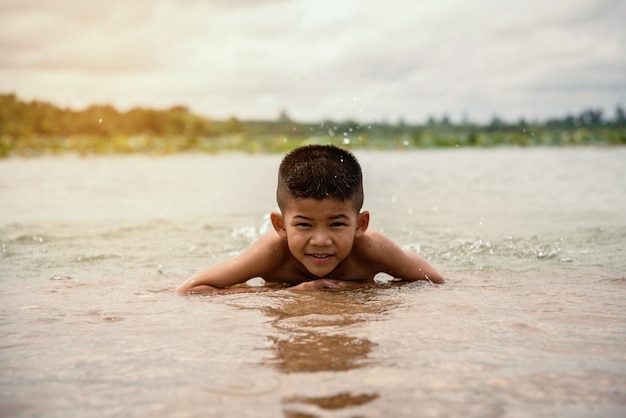 niño jugando al agua en el río