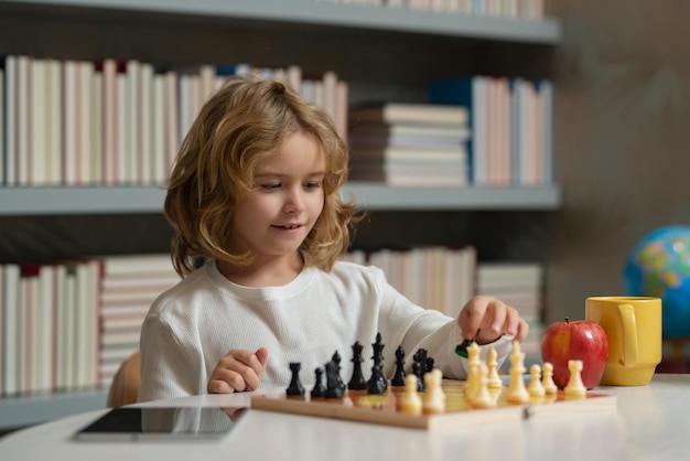 Niño jugando al ajedrez en la habitación Niño jugando al ajedrez Niño inteligente pensando en el ajedrez