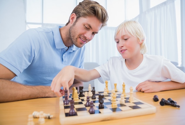 Niño jugando al ajedrez con su padre