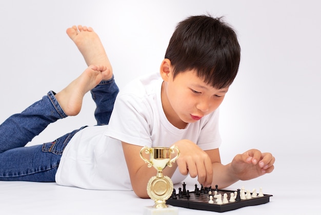 Niño jugando al ajedrez en el suelo