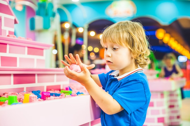 Niño jugando con arena cinética en preescolar