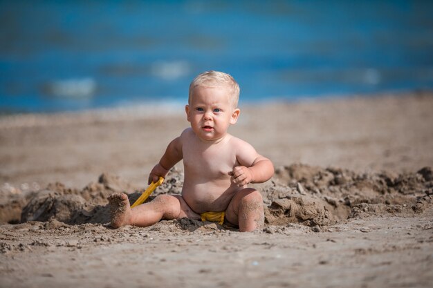 Niño jugando con arena junto al mar