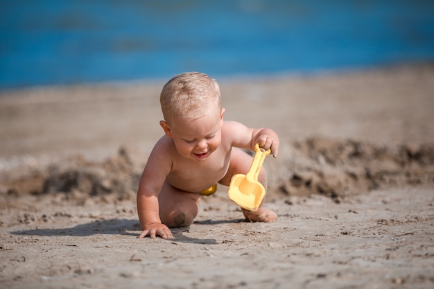 Niño jugando con arena junto al mar