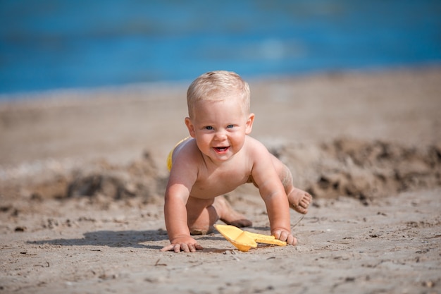 Niño jugando con arena junto al mar