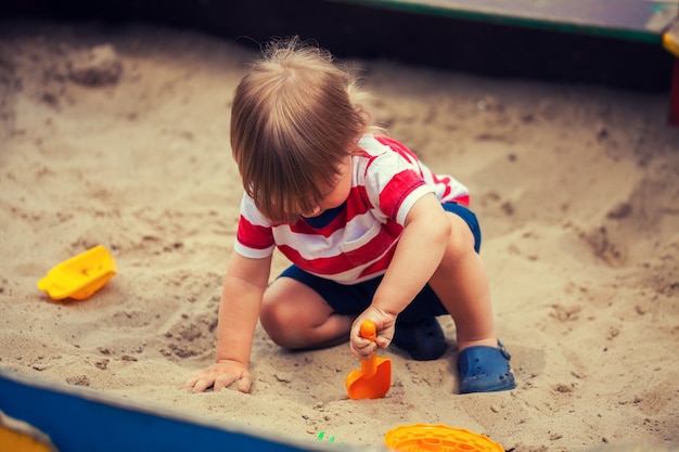 Niño jugando en el arenero