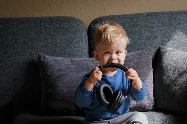 niño jugando con auriculares en el sofá