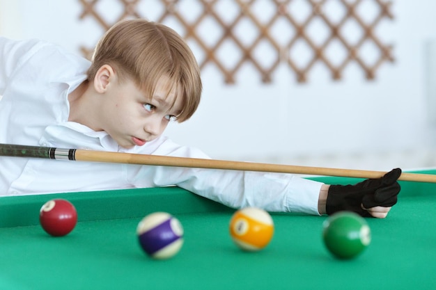 niño jugando billar