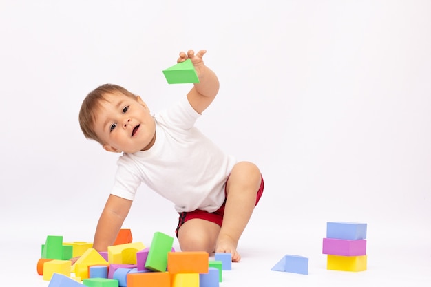 Niño jugando con bloques de construcción, aislado
