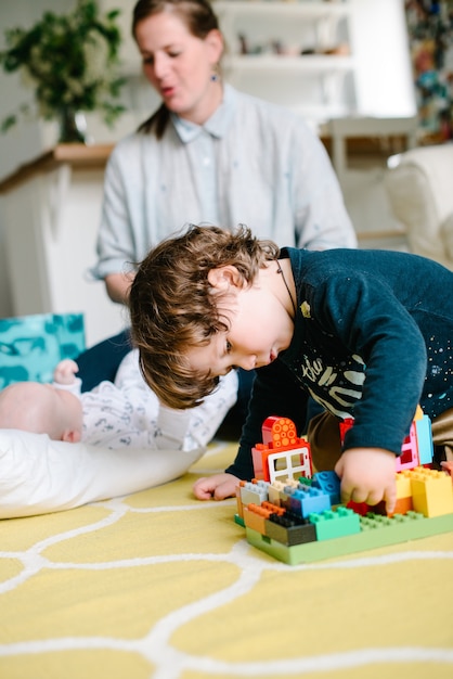 Niño jugando con bloques de construcción en casa en el piso