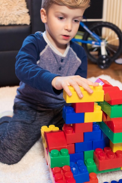 Foto niño jugando con bloques de juguete coloridos en casa