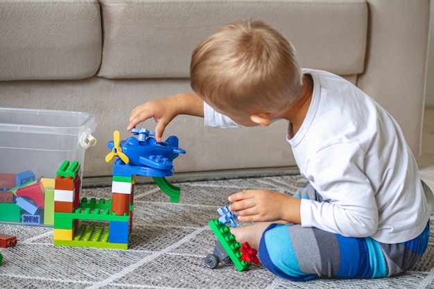 Niño jugando con bloques de juguete sentados en el suelo