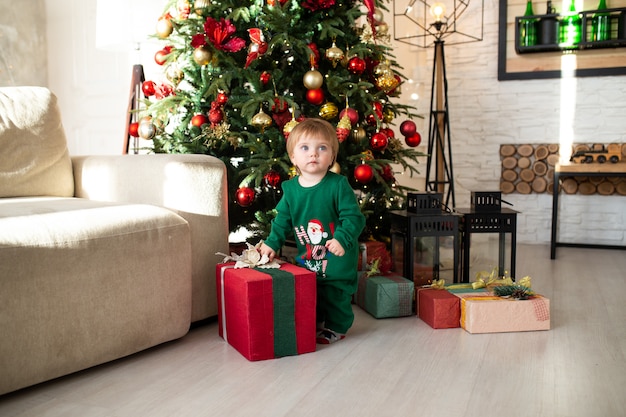 Niño jugando con cajas de regalo de Navidad