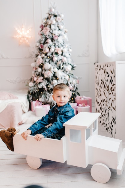 Niño jugando cerca del árbol de Navidad