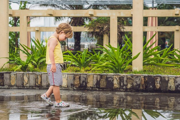 Niño jugando en un charco