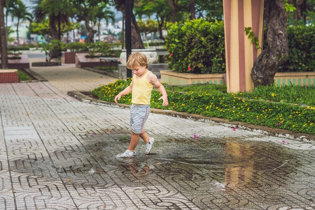 Niño jugando en un charco