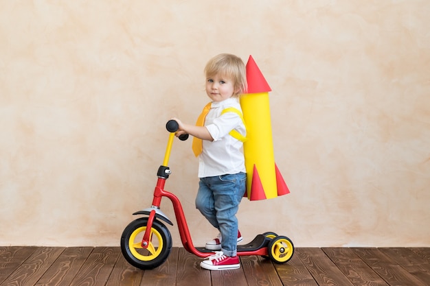 Niño jugando con cohete de papel interior