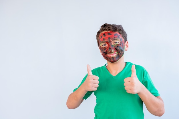 Niño jugando con colores usando sus manos y su cara.