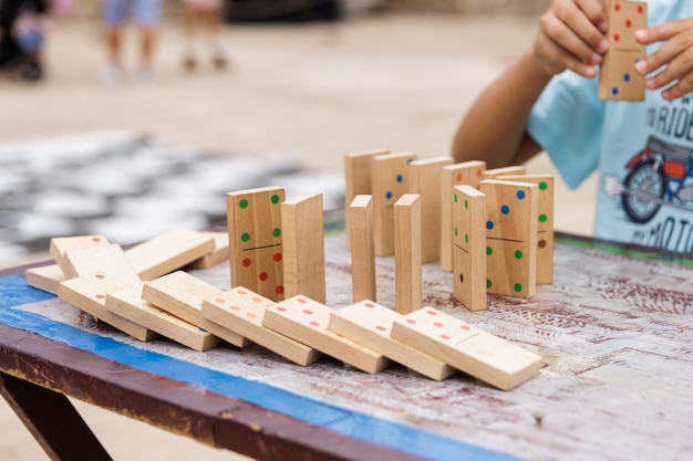 Niño jugando con dominó de madera afuera