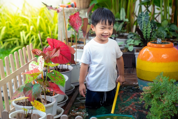 Niño jugando en un estanque koi