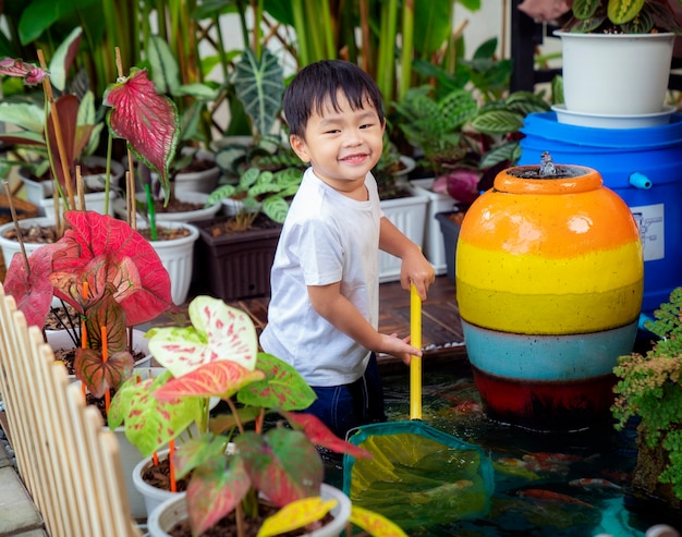 Niño jugando en un estanque koi