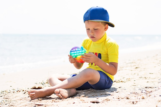 Niño jugando con fidget pop it on the beachNuevo juguete sensorial para niños y adultostop view