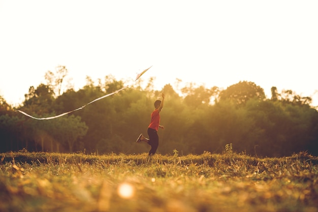 Niño jugando en el fondo del atardecer de campo