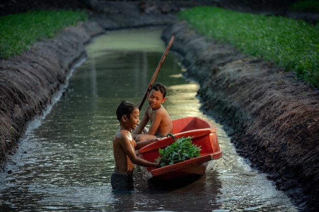 Niño jugando en una granja de verduras cerca del mercado flotante Damnoen Saduak, provincia de Ratchaburi