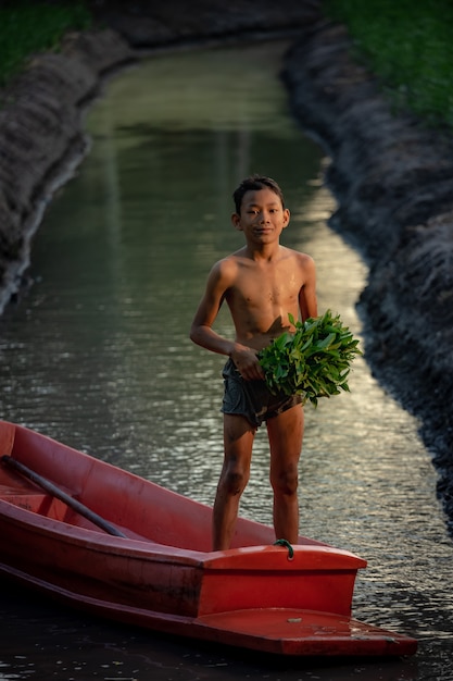 Niño jugando en una granja de verduras cerca del mercado flotante Damnoen Saduak, provincia de Ratchaburi