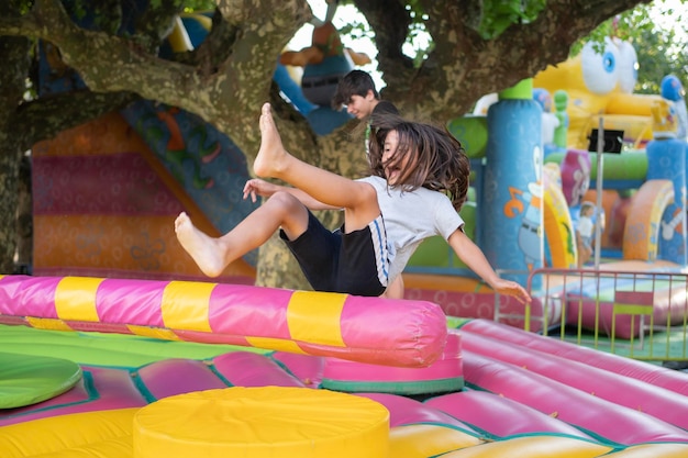 Foto niño jugando en el juego de tornado barrendero inflable en la feria