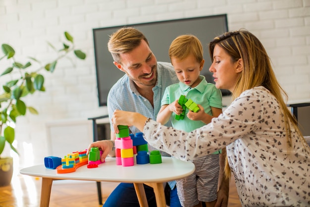 Niño jugando juguetes con la madre y el padre en casa