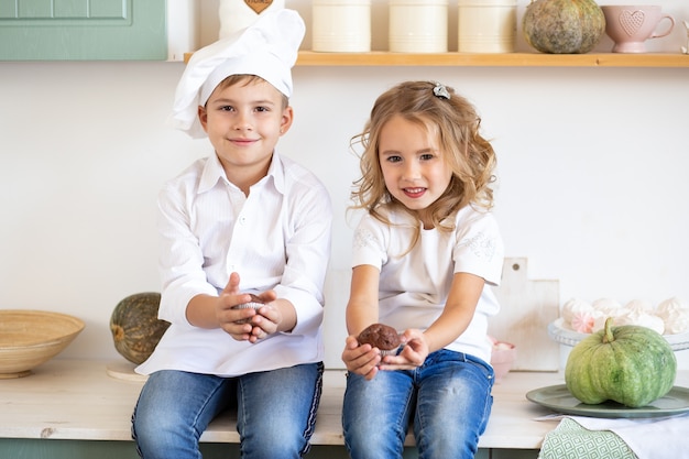 Niño jugando junto a su hermana en la cocina