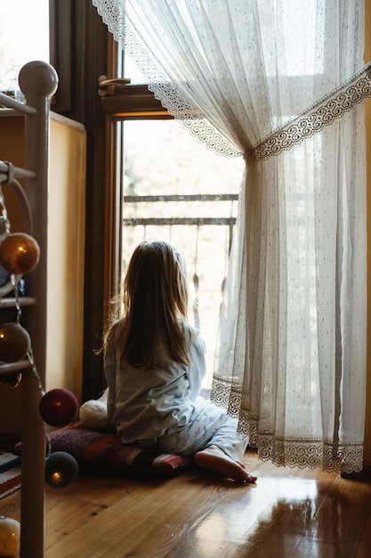 Niño jugando junto a la ventana en casa de ensueño