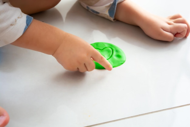 niño jugando con masa de juego en el suelo en casa