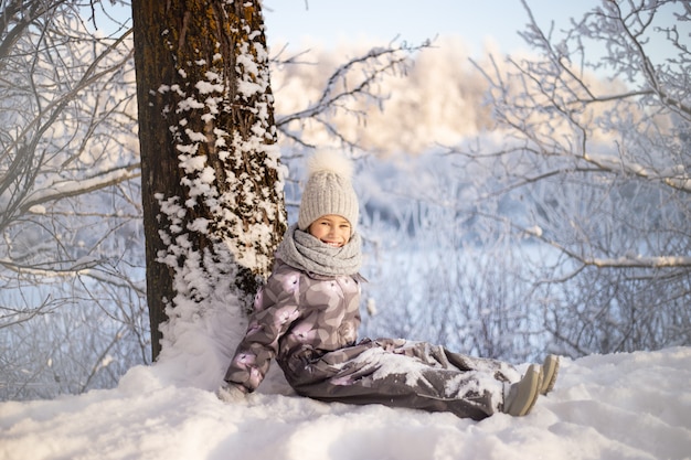 Niño jugando con nieve en invierno. Los niños atrapan copos de nieve