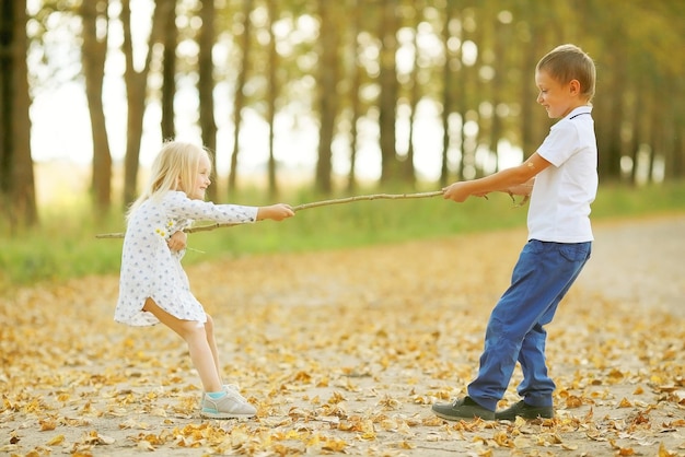 niño jugando con una niña en el otoño en el exterior