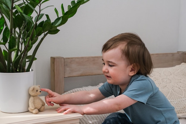 Niño jugando con un osito de peluche Niño jugando con su juguete favorito