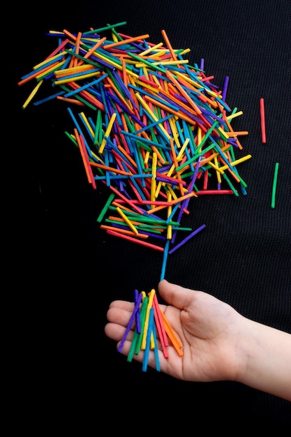 Niño jugando con palos de madera de colores para la creatividad