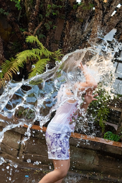 Niño jugando en el patio con agua en el verano brasileño