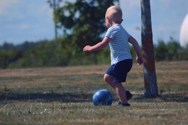 Niño jugando con la pelota en el campo