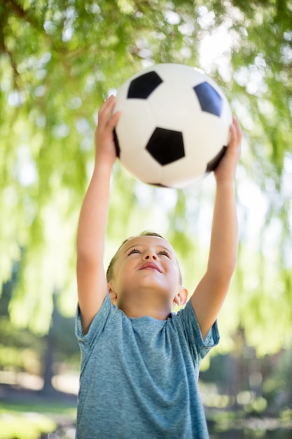 Niño jugando con una pelota de fútbol en el parque