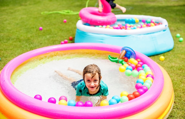 Niño jugando en una piscina de goma