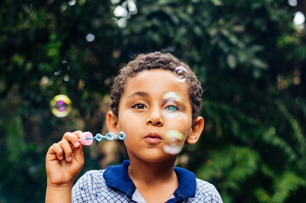 Niño jugando pompas de jabón