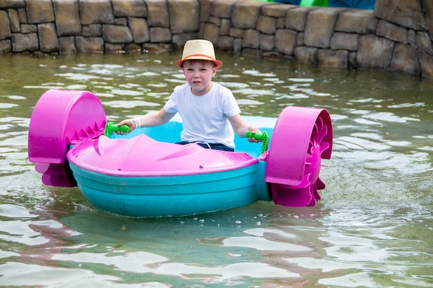 Foto niño jugando a remar en un bote de remos de agua enfoque suave foto de alta calidad